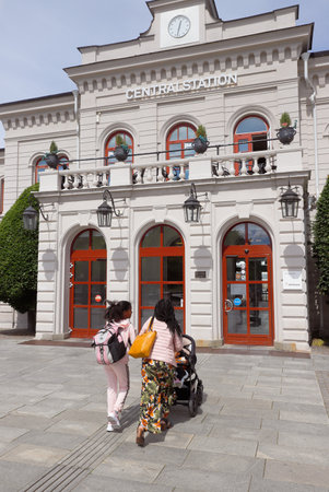 Norrkoping, Sweden - July 3, 2020: Two women with a stroller walking towards the railroad station entrance.のeditorial素材
