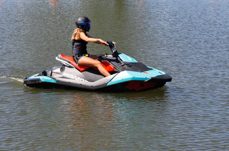 Mariestad, Sweden - June 23, 2020: One female jet ski rider running slow in the harbor.のeditorial素材