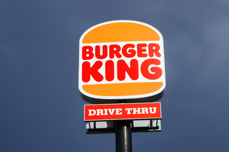 Eskilstuna, Sweden - May 17, 2021: Low angle view of the new rebranded Burger King logo on a pole outside the restaurant with drive thru isolated against a dark sky.のeditorial素材