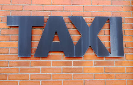 Taxi stand sign attached on a red brick wall.の写真素材
