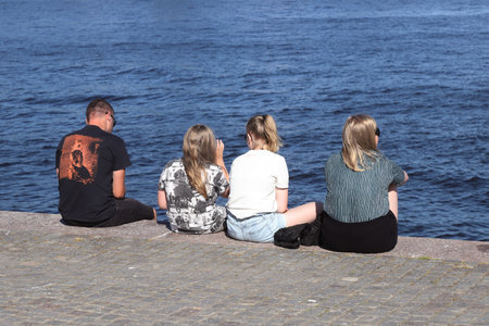 Stockholm, Sweden - July 21, 2021: A family is sitting on the quayside.のeditorial素材