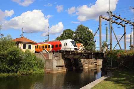 Norsholm, Sweden - August 5, 2021: An electric multiple unit set passenger train class X61 at the Gota canal bridge.のeditorial素材