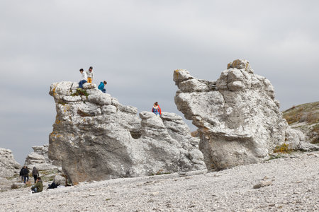Faro, Sweden - October 3, 2020: A group of three people visiting the Langhammar sea stacks area.のeditorial素材