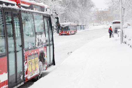 Sodertalje, Sweden - February 3, 2019: Lovisinsgatan street next to the railway station is a snow-covered street with public transport buses and bus stops.のeditorial素材