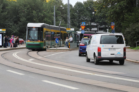 Helsinki, Finland - September 5, 2023: People, tram and traffic at the tram stop Olympia terminal.のeditorial素材