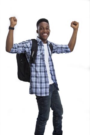 An excited young boy with hands raised up on isolated backgroundの写真素材