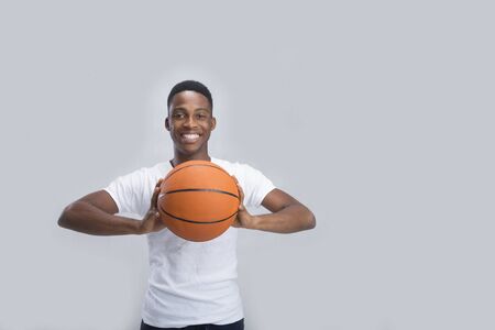 A young boy posing with a basketball on isolated backgroundの写真素材