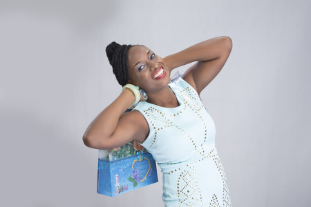 Excited young woman enjoying herself while carrying shopping bagsの写真素材