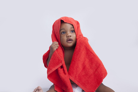 baby boy with a towel on his headの写真素材