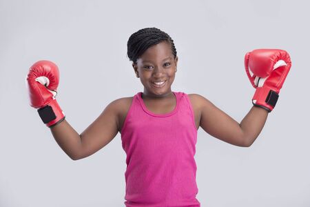 Cute little girl wearing a red boxing gloves showing her strength の写真素材
