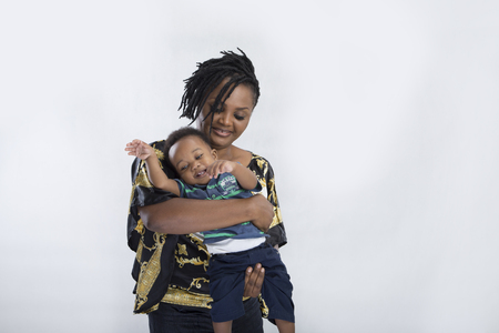 A lady carrying and holding baby with hand in between his legsの写真素材