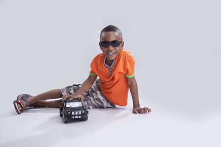 Handsome little boy playing with toy carの写真素材