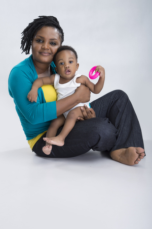 A woman sitting and carrying her baby with leg crossedの写真素材