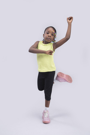 A little girl posing with hand raised up on isolated backgroundの写真素材