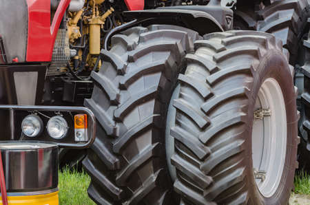 A large black tractor wheel with a tread designed for work on the farmの写真素材