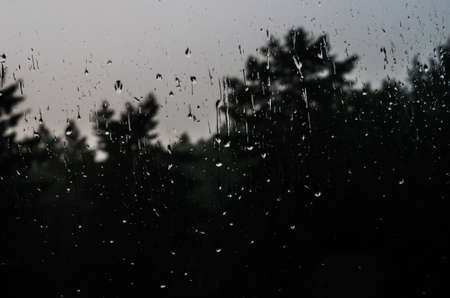 Drops of water on the window with an interesting pattern, formed during a pouring rain.