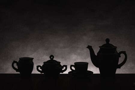 Dark silhouettes of ware for coffee on a gradient non-uniform backgroundの写真素材