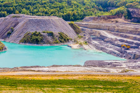 Water deposit and old marl quarry with a yellow dump truck in Sint-Pietersberg or Mount Saint Peter...