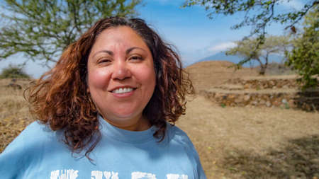 Beautiful Mexican woman smiling in front of the Guachimontones pre-Hispanic archaeological site with...