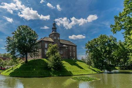 Limbricht castle surrounded by water and green trees on a wonderful sunny day in south Limburg, the Netherlands Hollandのeditorial素材