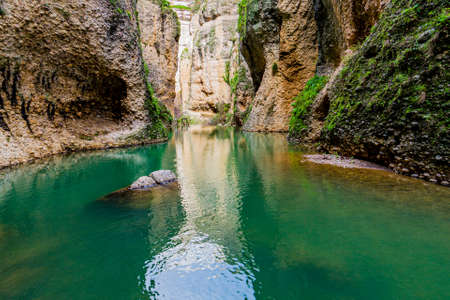 Guadalevin river between rocky slopes with green moss of the canyon or Tajo de Ronda with its turquoise waters, wonderful day in the province of Malaga Spainの写真素材