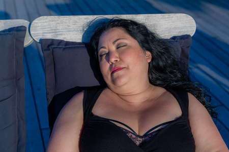 Beautiful, sexy, relaxed Mexican woman in black dress with neckline, lingerie and casual makeup,...