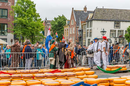 Alkmaar, North Holland / Netherlands. June 11th. 2016. Dutch cheese market with a large crowd, cheeses in the square, cheese bearers with straw hats and people in vintage clothingのeditorial素材