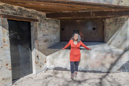Whale bunker in Burgh-Haamstede, Zeeland, Netherlands. April 26, 2021. Senior woman standing next to...