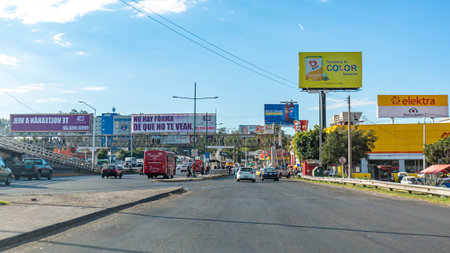 Guadalajara, Jalisco / Mexico. Jan. 20th. 2020. Departure from the city on the road to Chapala with light traffic, white pedestrian bridge and large commercial signs, sunny winter dayのeditorial素材