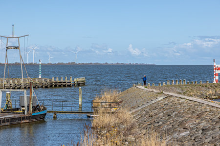 Entrance to Oosterhaven, the city harbor with its dike, floodgates, horizon, windmills and blue sky...