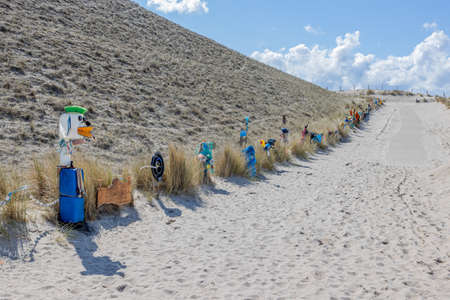 Petten aan Zee, North Holland, Netherlands. April 17, 2021. Open-air gallery next to the path to the beach conceived by Arnold Gronert, the Wall of Shame, art made with garbage collected on the beachのeditorial素材