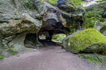 Huge rock with moss at the entrance of the rock formation Huel Lee or Hohllay an old quarry, hollow...