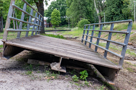 Old metal bridge removed from its place and temporarily placed on the bank of a stream, site under...