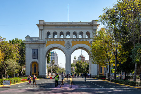 Guadalajara, Jalisco Mexico. January 8, 2023. Weekend recreational route, people enjoying, running, biking along avenue, Arches Monument in background, urban landscape with street closed for sportsのeditorial素材