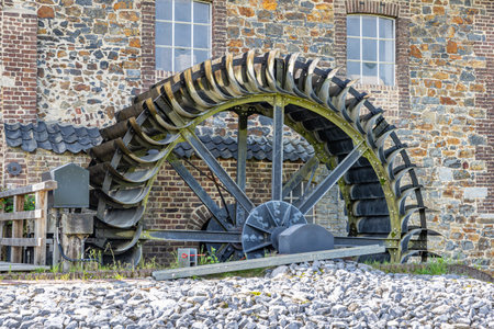 Old Eper or Wingbergermolen water mill on Geul river, stone wall with two windows, with its support,...