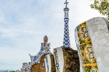Stone walls covered with colored tiles, dome on roof and surrealist style tower with cross, Porters...