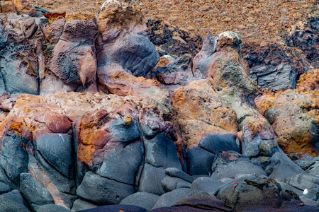 Rock face of hardened volcanic lava and stone on Mexican coast of Coronado Island, rough patterns on surface, black tinged with yellow, Loreto Bay National Marine Park, Baja California Sur, Mexicoの写真素材