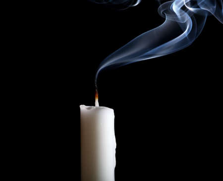 White candle isolated on black background.の写真素材