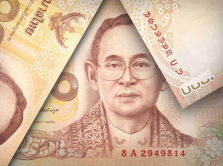 Money bills stacked over each other forming a money triangle.の写真素材