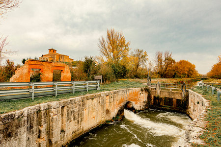 Autumn landscape with river and old brick bridge.の写真素材