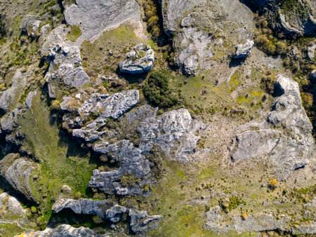 Drone photo showing abstract rock formations and green terrain from above. Natural landscape with geological textures and patterns, perfect for design or editorial use.の写真素材