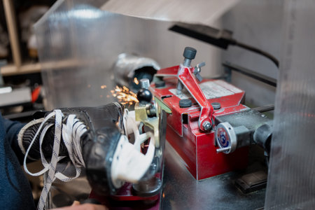 High precision hockey skate sharpening machine in operation with grinding sparks, focused on professional ice hockey equipment servicing industry