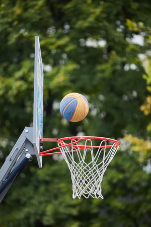 The ball of the sport of basketball flies to the basket. Street game, close-up of sports equipment.の写真素材