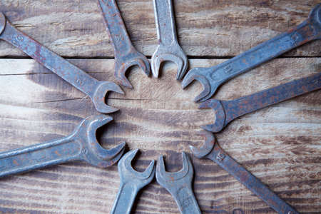 A set of working vintage wrenches lying on a wooden surface.の写真素材