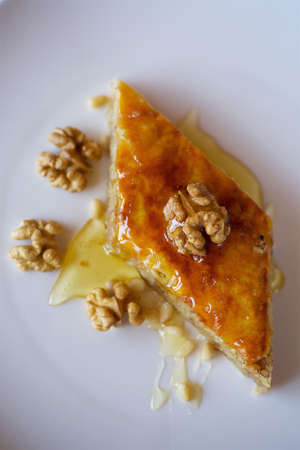 Close-up dessert is a piece of cake with walnuts, honey and pine nuts. Concept of confectioneryの写真素材