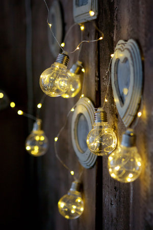 Vintage lamps with wires hang on the wall in the old-fashioned interior. In the background glare.の写真素材