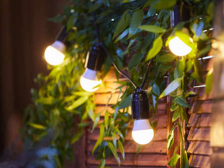Vintage lamps with wires hang on the wall in the old-fashioned interior. In the background glare.の写真素材