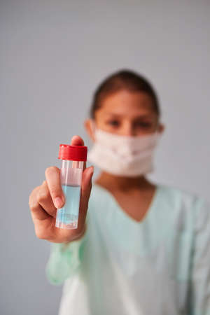 The flask with the analysis of biological material in the hands of the doctor. Concept of medicine and disease prevention.の写真素材
