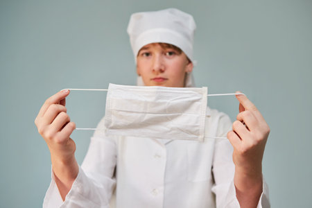 Face mask for protection from infection in the hands of a doctor. Concept of medicine and disease prevention.の写真素材