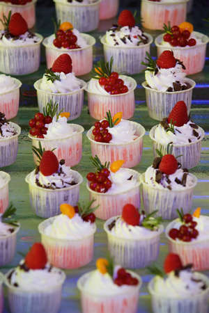 Beautiful and bright desserts on the festive table for the party. Confectionery with cream and marzipan.の写真素材